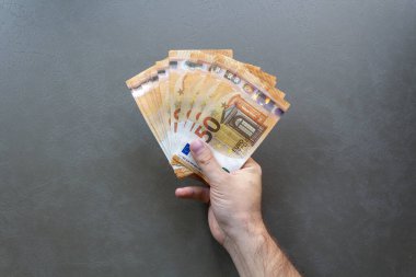 Euro Banknotları Sayan Adam. Avro banknotlarını tutan ve sayan bir adam, yakın plan el ve para.
