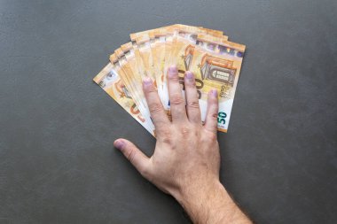 Euro Banknotları Sayan Adam. Avro banknotlarını tutan ve sayan bir adam, yakın plan el ve para.