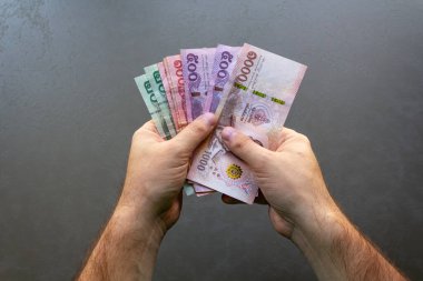 Tayland Baht Banknotları Sayan Adam. Elinde bir yığın Tayland Baht banknotunu tutan ve sayan bir adam, ellerine ve parasına odaklan..