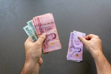 Tayland Baht Banknotları Sayan Adam. Elinde bir yığın Tayland Baht banknotunu tutan ve sayan bir adam, ellerine ve parasına odaklan..