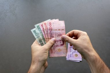 Tayland Baht Banknotları Sayan Adam. Elinde bir yığın Tayland Baht banknotunu tutan ve sayan bir adam, ellerine ve parasına odaklan..
