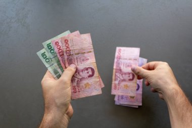 Tayland Baht Banknotları Sayan Adam. Elinde bir yığın Tayland Baht banknotunu tutan ve sayan bir adam, ellerine ve parasına odaklan..
