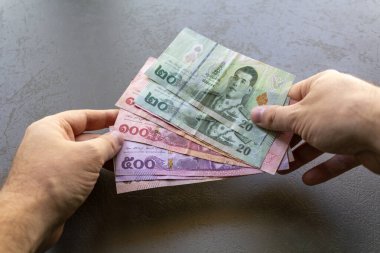 Tayland Baht Banknotları Sayan Adam. Elinde bir yığın Tayland Baht banknotunu tutan ve sayan bir adam, ellerine ve parasına odaklan..