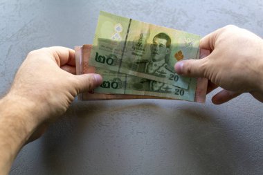 Tayland Baht Banknotları Sayan Adam. Elinde bir yığın Tayland Baht banknotunu tutan ve sayan bir adam, ellerine ve parasına odaklan..