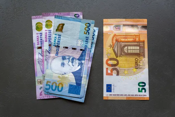 Arnavutluk Lek ve Euro Banknotes on Table. Arnavutluk Lek ve Avro banknotlarının yer aldığı bir masanın yakınlaştırılması, döviz karşıtlığını temsil ediyor.