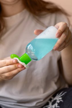 Elinde bir şişe toner tutan ve pamuk yastığını ıslatan genç bir kadının aşırı yakın çekimi. Ev cilt bakımını, yüz bakımını ve güzellik ürünlerini ön plana çıkarıyor. 