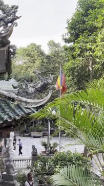 Süslü ejderha ve anka kuşu çatı süslemeleri, yemyeşil ve sakin avluların yer aldığı geleneksel bir Vietnam tapınağının çarpıcı detaylarını araştırın.. 
