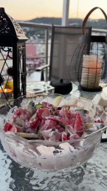 Kavala, Yunanistan: Yaz akşamı balkon yemeği. Taze karides, salata, peynir. Tepelerde mum ışığında gün batımı.