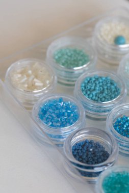 Temiz bir tepside dizilmiş bu küçük kaplar renkli mavi, yeşil ve beyaz tohum boncuklarına sahiptir. & Mücevher projeleri için ideal.