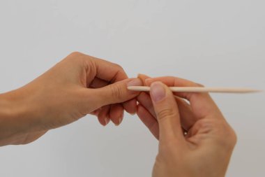 Beyaz arka planı temizlemek için pamuklu bez kullanan kadın eli.