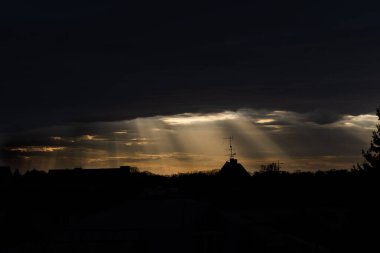 Bulutlar ve güneş ışınlarıyla dramatik gün batımı.