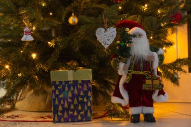 Noel ağacı, hediyeler ve tahta bir arka planda Noel Baba. Noel süslemeleri, Noel ağacı, oyuncaklar, oyuncaklar ve hediyelerle Noel konsepti.