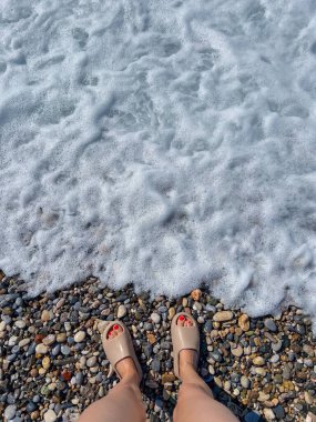 Karadeniz 'de beyaz arka planda kadın bacakları. yaz tatili.