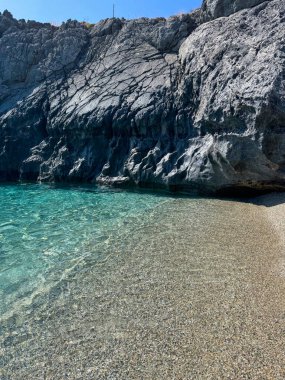 Mavi su ve deniz taşları. Yunanistan 'ın Girit adasının Rocky sahilleri. Yaz manzarası.