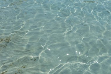 Deniz suyu yüzeyinin dokusu küçük dalgalar ve güneş yansımalarıyla.
