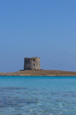 Caletta della Torre La Pelosa sahilindeki harabe kule manzarası.