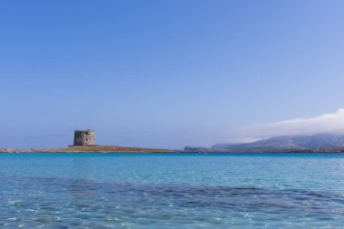 Caletta della Torre La Pelosa sahilindeki harabe kule manzarası.
