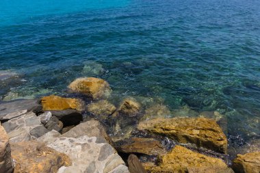 Kayalar ve turkuaz deniz suyuyla tropik plaj.