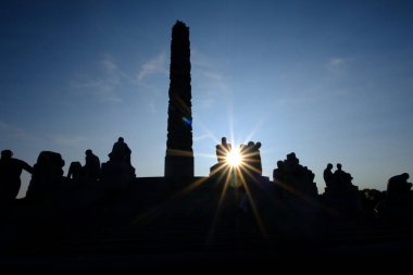 Monolit heykelin silueti ve açık mavi gökyüzü ile Vigeland Park, Oslo 'da bir güneş yıldızı.
