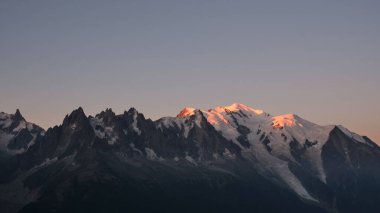 Sabahın erken saatlerinde, Mont Blanc dağ zirvesini aydınlatan gün ışığı.