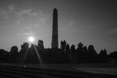 Monokromatik Monolit heykel silueti ve Vigeland parkında bir güneş yıldızı, Oslo