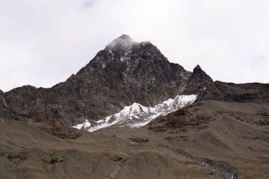 İtalyan Alplerinde karla kaplanmış dramatik kahverengi dağ manzarası