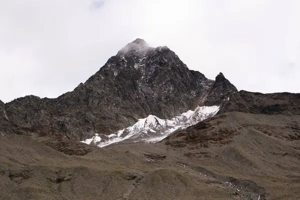 İtalyan Alplerinde karla kaplanmış dramatik kahverengi dağ manzarası