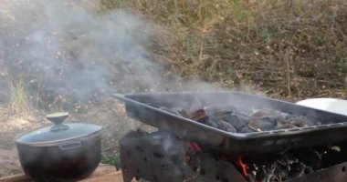 Kabuklu deniz ürünleri midyeleri bbq Grill 'de pişirilir. Kazan ve siyah deniz kabuğu midyeleri alevler ve dumanla ateşe hazırlanıyor. Kamp yemekleri dışarıda.
