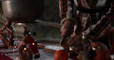 Tahta kesme tahtasında limon dilimleyen eller. Noel zamanı yemek pişirmek. Kadın taze limonlu narenciye kesip pota koymuş. Ön planda yanıp sönen ışıklar. Dikkat çekmeden, bokeh 'in dikkatini dağıtmak için hareket ediyor.