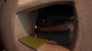 El, yakacak odun ve çıra dolu bir odun ocağına çakmakla ateş yakar. Çiftlik evinin eski bir şöminesinde nasıl ateş yakılacağını. Yanan odunlu otantik Slav sobası. Fisheye merceği