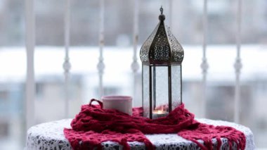 İçinde yanıp sönen mum ve kırmızı eşarba sarılı sıcak çay ve yükselen buharla Ramazan feneri. Açık havada Arap tarzı klasik lamba. Sıcak bardak ve süslü mum tutacağıyla dolu bir hayat.