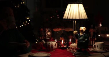 Kadınlar güzel bir Noel masasının etrafında sıcak bir tatil çay saatinin tadını çıkarırlar. Kaprisli domuz lambası ortam ışıklandırmasıyla şenlikli atmosfere cazibe katıyor..