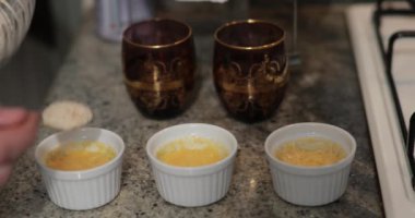 Lezzetli bir muhallebi tatlısı hazırlamak, temiz bir mutfak tezgahında zarif içki bardaklarının yanında sergilenmek. Lezzetli bir ikram için adım adım pişirmek.