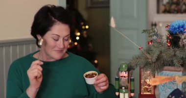 Kadınlar, Noel süsleme odasında tatlı ve kaşık tutarken gülümsüyor. Kaşığı kırık bir kadın karamelize şeker kabuğu kremalı brulee tatlısını ünlü filmdeki gibi