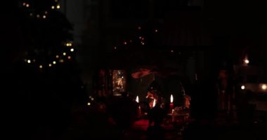 Mumlu ahşap atlıkarınca festival dekorasyonları arasında nazikçe dönüyor ve bir tatil toplantısında sıcak ve davetkar bir atmosfer yaratıyor. Noel ışıkları ve yumuşak mumlarla dolu gece sahnesi