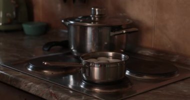 Yumurtalar Paskalya yumurtası boyama işlemi için kaynatılır. Mutfak ocağında metal tava. 