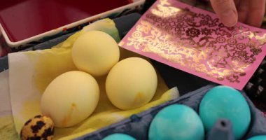 Paskalya yumurtalarını renkli çıkartmalar ve mavi sarı tasarımlarla süsleyerek yumurta boyama işlemini öğrenin. Bu tatil sezonunda şenlikli dekorasyonlar yapmak için ilham alın..