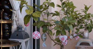 Canlı Paskalya Yumurtası süslemeleri büyüleyici bir açık havada canlı bir Paskalya ağacına asılır. Ağaç, şenlikli atmosferi güçlendirmek için güzelce işlenmiş piranka ile süslenmiş..