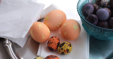 Çok güzel boyanmış bıldırcın yumurtaları da dahil olmak üzere çeşitli Paskalya yumurtaları bir masada sergilenmektedir..