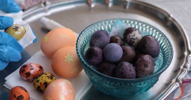 Renkli Paskalya yumurtaları ve eşsiz bıldırcın yumurtaları gümüş tepside oturur. Canlı renklerde boyanmış yumurtalar, gösterişli, karmaşık tasarımlar ve şenlikli eğlenceye davetiye çıkarıyor..