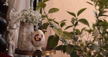 Bahar evi dekorasyonu, zarif bir çiçek aranjmanı ve büyüleyici bir yumurta içeren canlı Paskalya süslemeleri ile geliştirilir. Toplantılar için sıcak bir atmosfer yaratır..