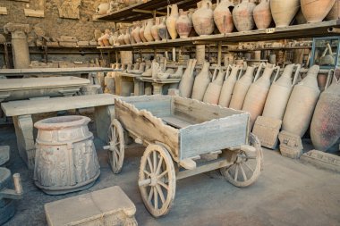 Pompeii, İtalya 'daki tarihi bir depodaki antik çömlek, heykel ve eserler hakkında detaylı bir görüş. Kompozisyon, tarih meraklıları ve kültür kaşiflerine hitap ederek arkeolojik önemi sergiliyor ve Roma zanaatkarlığını koruyor.