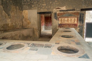 Pompeii 'de görülebilir freskleri ve yiyecek hazırlama tezgahları olan antik Roma döneminden kalma bir termopolit..