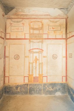 Ayrıntılı bir fresk Pompeii, İtalya 'dan karmaşık klasik tasarımlar sergilenen antik bir odanın duvarını süslüyor. Korunmuş sanat eserleri antik Roma medeniyetinin canlı kültürel mirasını yansıtıyor..