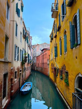 Charming Venetian Canal With Vibrant Yellow and Orange Buildings and Tranquil Water in Venice, Italy. A peaceful canal in Venice, Italy, framed by colorful yellow and orange historic buildings 