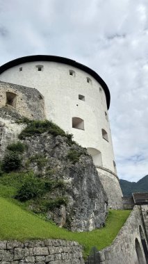 05.08.2024 Austria: A magnificent view of the Kufstein Fortress in Austria, perched on a hill with its round white tower standing out against the cloudy sky. The fortress is surrounded by lush clipart