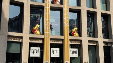 28.03.2025 Avusturya: Alışveriş Merkezi Kaufhaus Tyrol Paskalya Dekorasyonları Lindt Golden Bunnies ile. Avusturya, Innsbruck 'taki Kaufhaus Tyrol alışveriş merkezinde paskalya süsleri. Modern bina cephesi