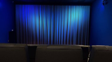 Mavi Perdeli Boş Sinema Salonu ve Konforlu Koltuklar. Mavi perdeler ve modern koltuklar sergilenen sakin bir atmosferi çağrıştıran sakin bir iç mekan..
