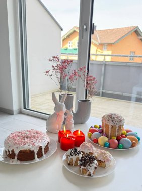 Şenlikli tatlı sergisi renkli pastalar, dekoratif mumlar ve Paskalya temalı dekorasyonlar, bahar şenlikleri sırasında kutlama ve toplanma için ideal neşeli bir atmosfer yaratıyor.