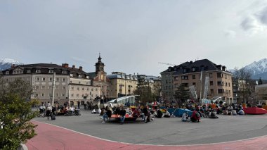 Innsbruck, Avusturya - 28 Mart 2025: Innsbruck, Avusturya 'da halk meydanı tarihi binalar ve dağlarla çevrili boş zamanların keyfini çıkaran insanlarla dolu 